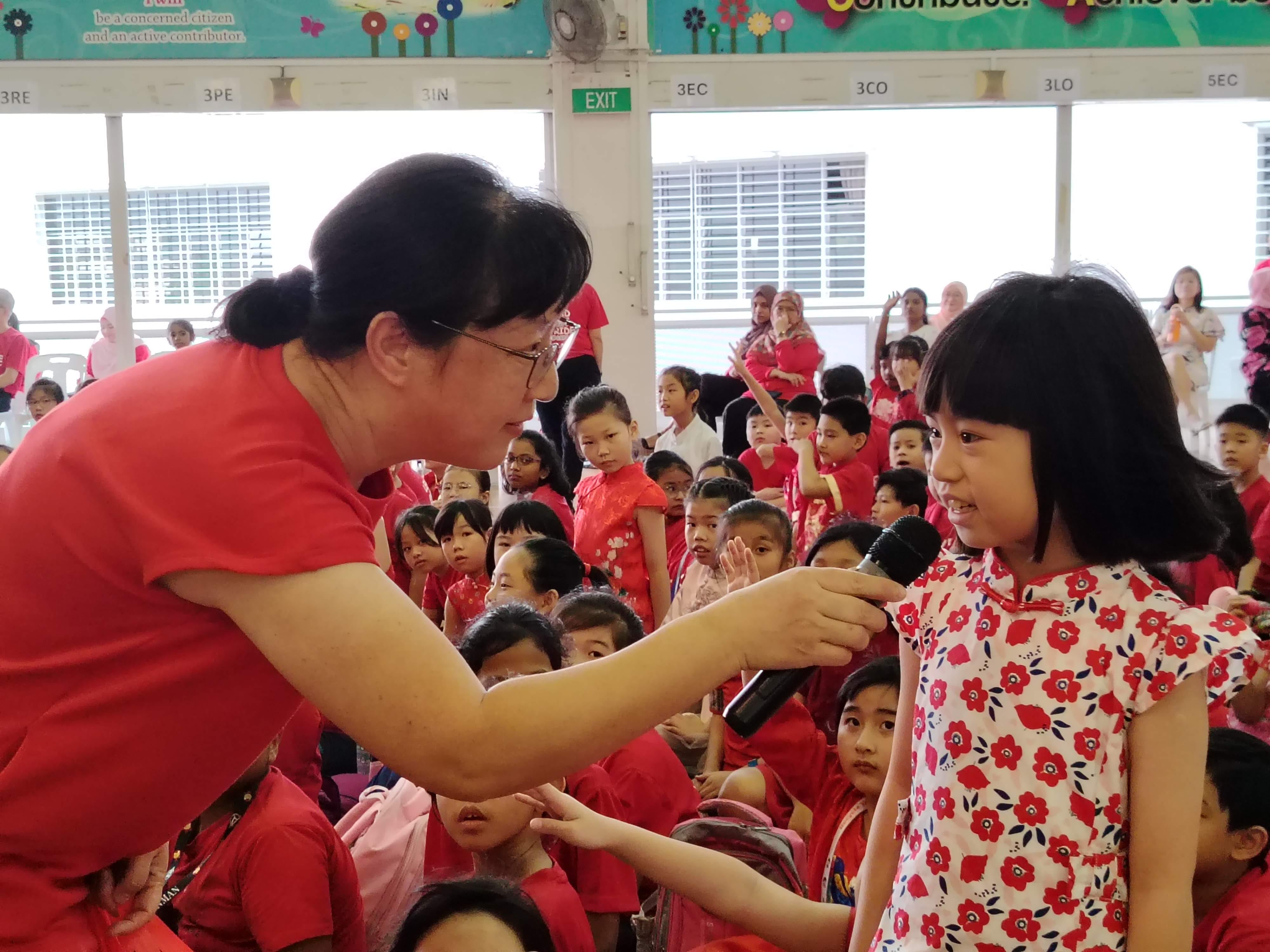 A student answers into the mic as a teacher asks a quiz question